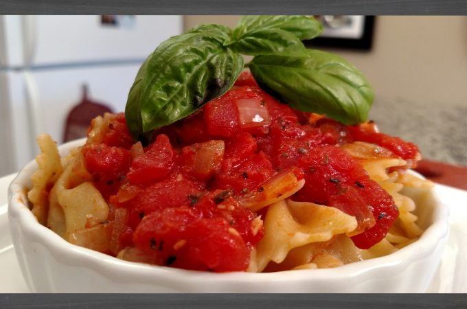 Tomato Sauce on farfalle pasta in white dish with basil