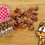 spilled jar of Candied Pecans on bamboo cutting board with 2D animated squirrel