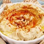 Bowl of Hummus with Pine Nuts and Pita Bread
