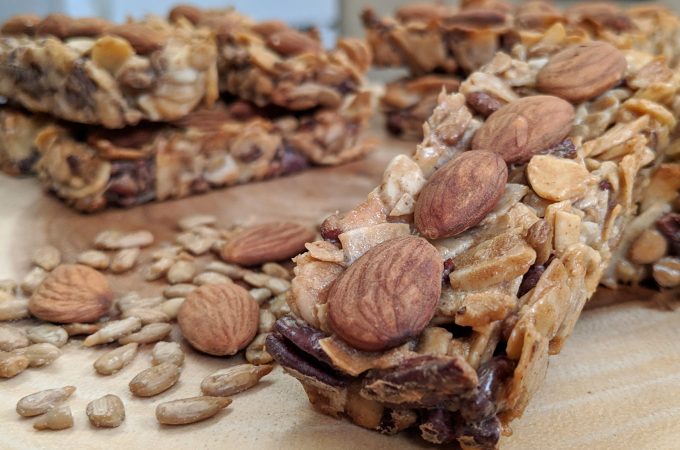 Tiny Kitchen Zip Bars (Keto Granola Bars) with Almonds, Coconut, Sunflower Seeds, Pecans stacked on a wooden board