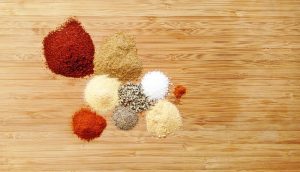 piles of spices on bamboo cutting board